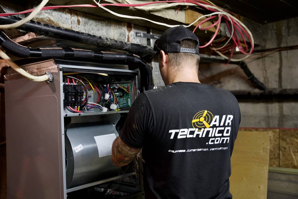 technicien qui installe un système de ventilation